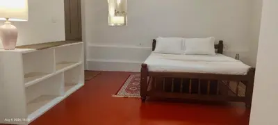 a small bedroom with a bed and white shelves at Cuppa Creek Homestay in Madikeri