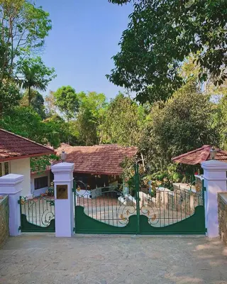 a green gate in front of a house at Cuppa Creek Homestay in Madikeri