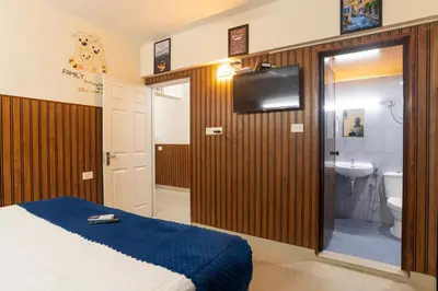 a bedroom with a bed and a bathroom with a sink at Sancta Maria in Nedumbassery