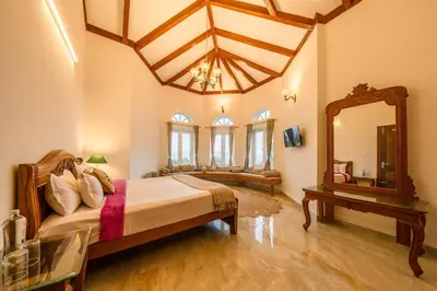 a bedroom with a large bed and a mirror at Emerald Stays Ooty By VOYE HOMES - Italian Luxury near Ooty Emerald Lake in Ooty