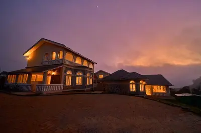 a large house with lights on at night at Emerald Stays Ooty By VOYE HOMES - Italian Luxury near Ooty Emerald Lake in Ooty