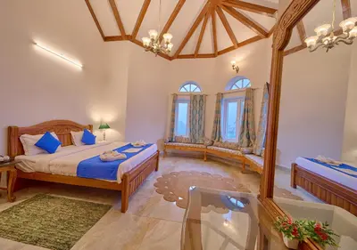 a bedroom with two beds and a glass table at Emerald Stays Ooty By VOYE HOMES - Italian Luxury near Ooty Emerald Lake in Ooty