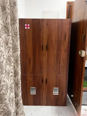 a large wooden cabinet in a room at Sahar Home Stay 01 in Mysore