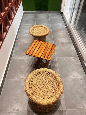 two wicker chairs and a wooden bench on a porch at Sahar Home Stay 01 in Mysore