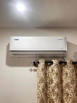 a white air conditioner hanging from a ceiling at Sahar Home Stay 01 in Mysore