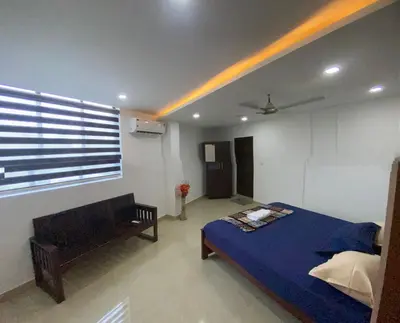 a bedroom with a blue bed and a window at moona apartments in Malappuram
