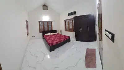 a bedroom with a pink bed in a white room at 3 BHK HOUSE with nice facilities,Gate&Fence in Kunnamangalam