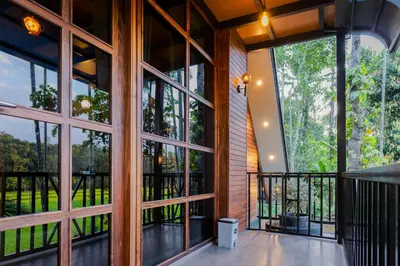 a room with large windows and a balcony at Ethnic Villa Wayanad in Kenichira