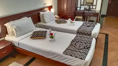 two beds in a hotel room with flowers on them at Hotel Afrad International in Kondotti