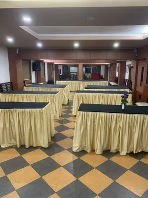 a large room with tables and chairs in a building at Hotel Afrad International in Kondotti