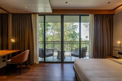a hotel room with a bed and a balcony at Morickap Lord's 83, Trademark Collection by Wyndham in Meenangadi