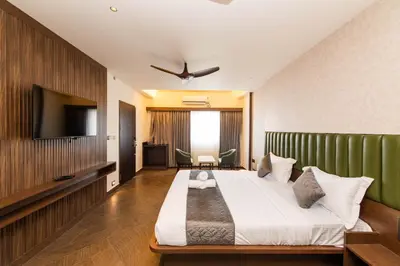 a bedroom with a large bed and a flat screen tv at Hotel Mysore Radiance in Mysore