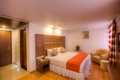 a hotel room with a bed and a chair at The Atrium Boutique Hotel in Mysore