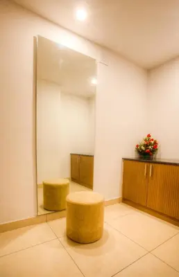 a waiting room with a mirror and a stool at The Atrium Boutique Hotel in Mysore