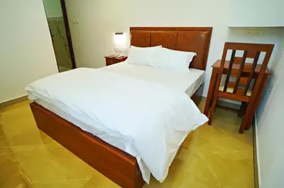 a bedroom with a large bed and two chairs at GH Grand Park in Angamali