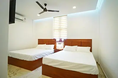 a bedroom with two beds and a ceiling fan at GH Grand Park in Angamali