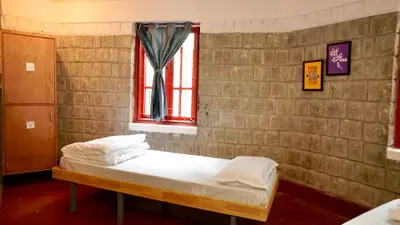 a bed in a room with a brick wall at Roambay - Gokulam in Mysore