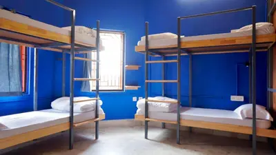 two bunk beds in a room with a blue wall at Roambay - Gokulam in Mysore