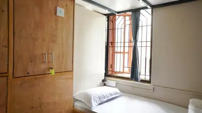 a room with a bed and a window in a room at Roambay - Gokulam in Mysore
