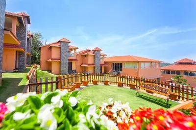 a house with a wooden fence and a yard with flowers at Royal Crown resorts in Kotagiri