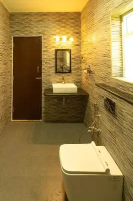 a bathroom with a white toilet and a sink at Royal Crown resorts in Kotagiri