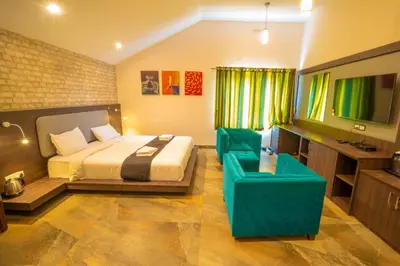 a bedroom with a bed and a couch and a television at Royal Crown resorts in Kotagiri