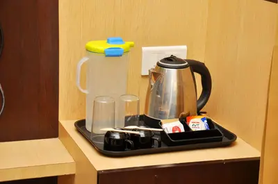 a tray with a tea kettle and cups on a counter at Harikrishna Park in Coimbatore