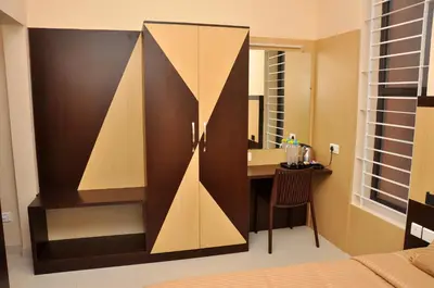 a bedroom with a desk and a mirror at Harikrishna Park in Coimbatore