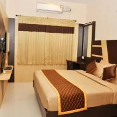 a bedroom with a bed with a desk and a window at Harikrishna Park in Coimbatore