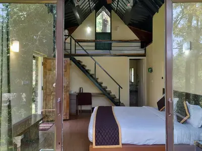 a bedroom with a bed and a spiral staircase at Gorukana Eco Wellness Centre in Honganūr