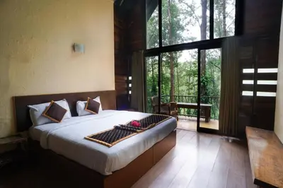 a bedroom with a bed and a large window at Gorukana Eco Wellness Centre in Honganūr