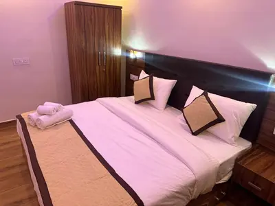 a bedroom with a large bed with pink sheets and pillows at Golden hills cottage in Viripara