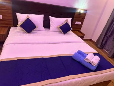 a bed with purple pillows and purple towels on it at Golden hills cottage in Viripara