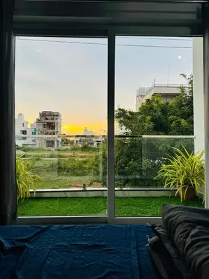 a room with a large window looking out at a city at Stayover Homestay in Mysore