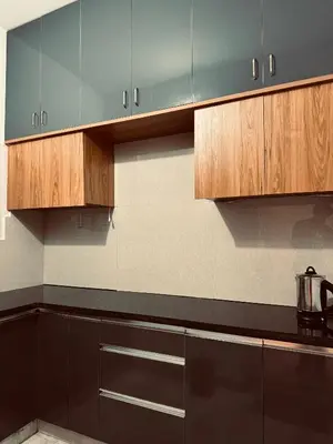 a kitchen with wooden cabinets and a tea kettle at Stayover Homestay in Mysore