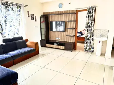a living room with a couch and a tv at Mannat Inn Classic Premium - 3BHK in Mysore