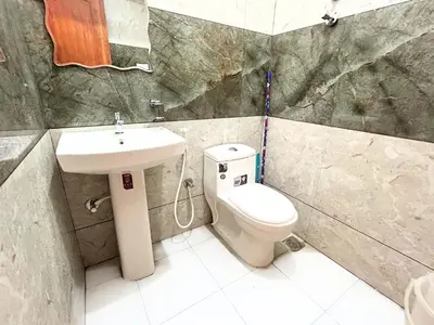 a bathroom with a toilet and a sink at Mannat Inn Classic Premium - 3BHK in Mysore