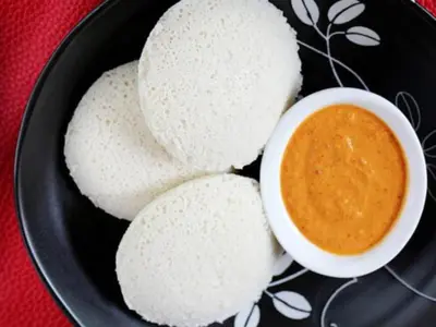 a plate of food with a bowl of dipping sauce at Mannat Inn Classic Premium - 3BHK in Mysore