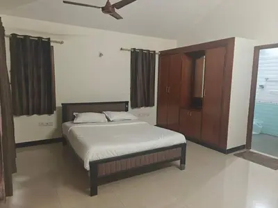 a bedroom with a bed and a cabinet and a ceiling fan at Emerald Luxury Villa in Mysore