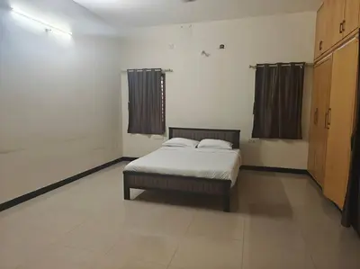 a bedroom with a bed in the middle of a room at Emerald Luxury Villa in Mysore