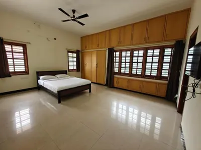 a bedroom with a bed and a ceiling fan at Emerald Luxury Villa in Mysore