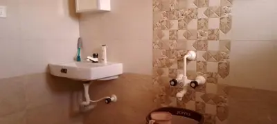 a bathroom with a sink and a toilet in it at Beyond Ghatts Homestay in Dhali