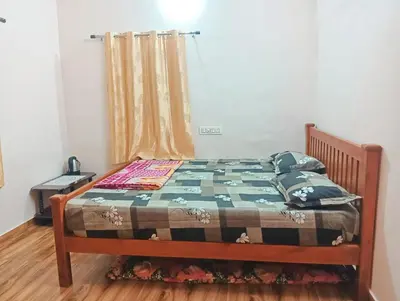 a bed with a quilt on it in a bedroom at KPR Residency Near Isha - Adiyogi in Alāndurai