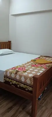 a bed with a comforter on top of it at KPR Residency Near Isha - Adiyogi in Alāndurai