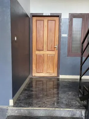 a wooden door in a room with a staircase at Scott legacy apartment in Kulattūr