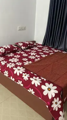 a bedroom with a bed with white flowers on it at Scott legacy apartment in Kulattūr