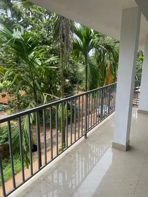 a balcony with a black railing and palm trees at Scott legacy in Kulattūr