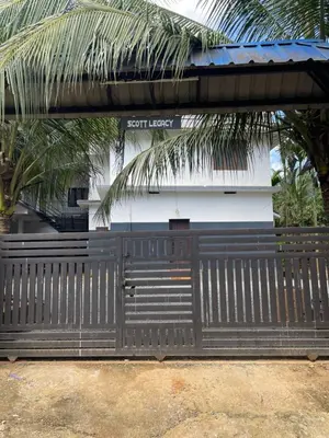 a black gate in front of a building at Scott legacy in Kulattūr
