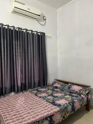 a bedroom with a bed with a curtain and a fan at Scott legacy in Kulattūr