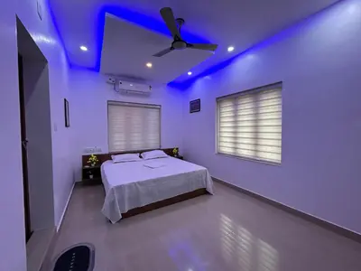 a bedroom with a bed and a ceiling fan at Puzhayoram Homestay in Trichūr
